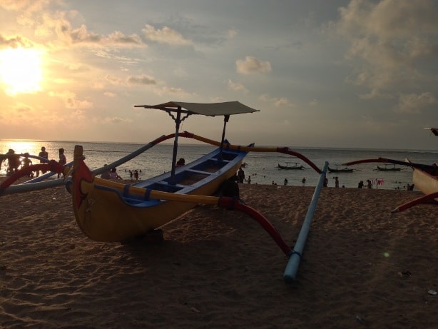 Bateaux traditionnels sur la plage de Kuta à Bali au coucher de soleil 
