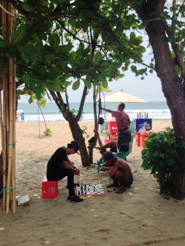 Joueurs d’échecs indonésiens sur la plage de Kuta Beach a Bali