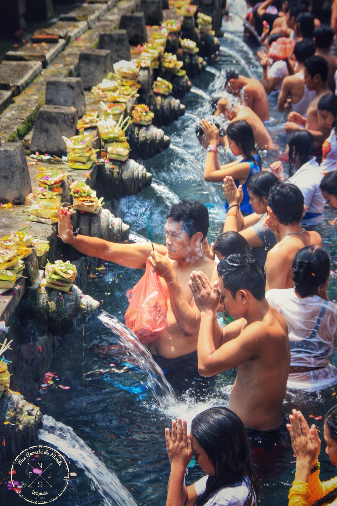 Procession et immersion des pélerins dans les eaux sacrées du temple de Tirta Empul à Bali