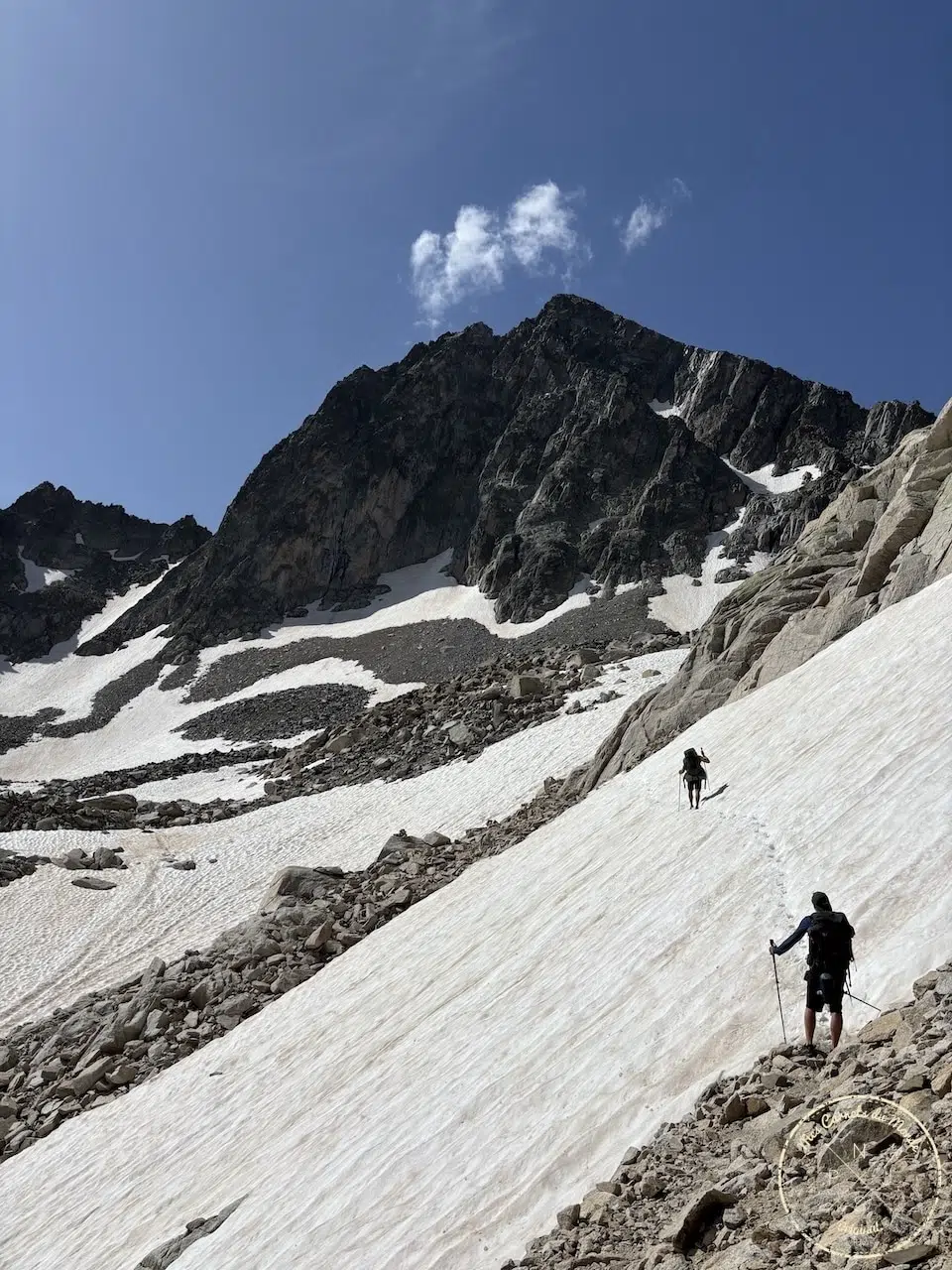 Traversée d'un névé très en pente, sous un pic dans les Pyrénées